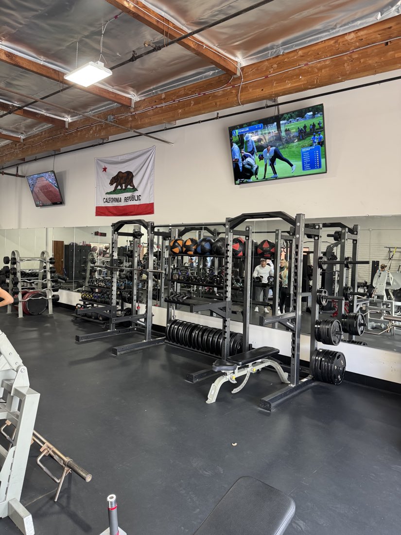 Squat racks and loaded barbells at the studio